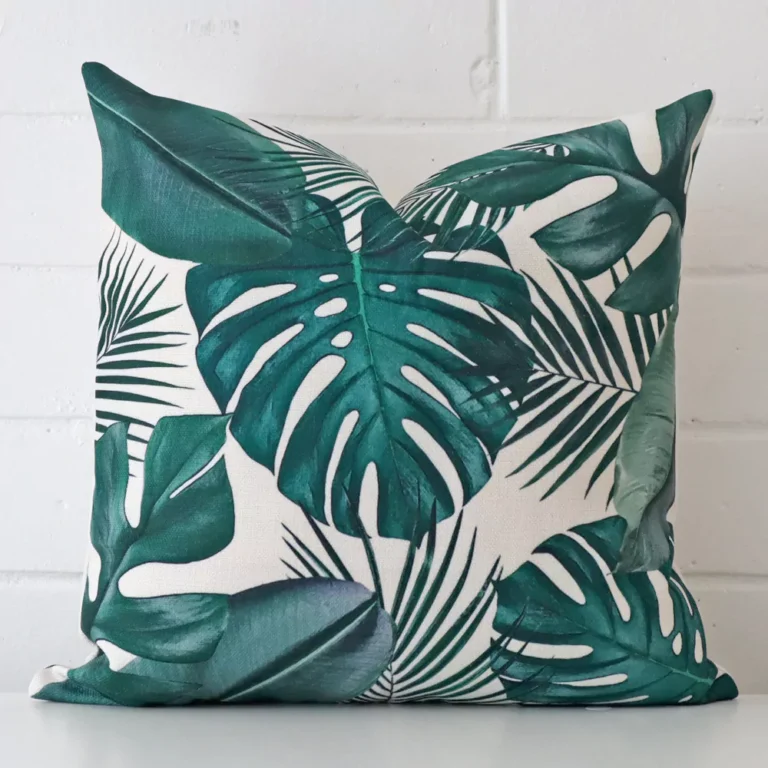 Here a linen cushion is shown styled against a white wall. It has a square design.