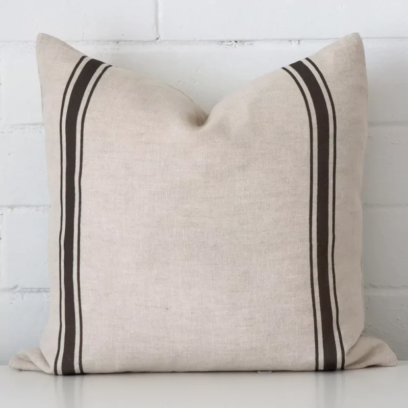 lyla-linen-charcoal-striped-cushion-cover-sc1006-45b Charcoal striped cushion leans elegantly against a brick wall. It has been crafted from a high quality striped material and has a square shape.
