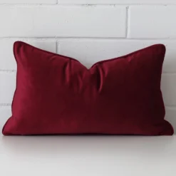 A bold linen cushion in a sleek rectangle size with a maroon tone of colour.