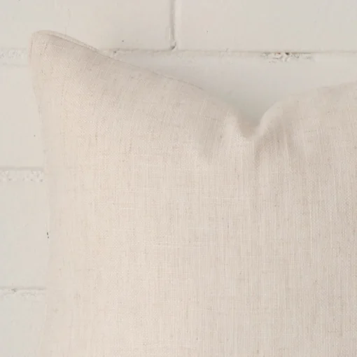 A linen square cushion’s corner has been enlarged in this shot. The detail of the TYPE design and cream colour are visible.
