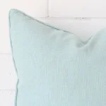 A magnified shot of a linen cushion cover in a square size and a mint colour.