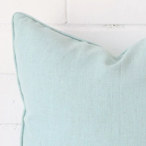 A magnified shot of a linen cushion cover in a square size and a mint colour.