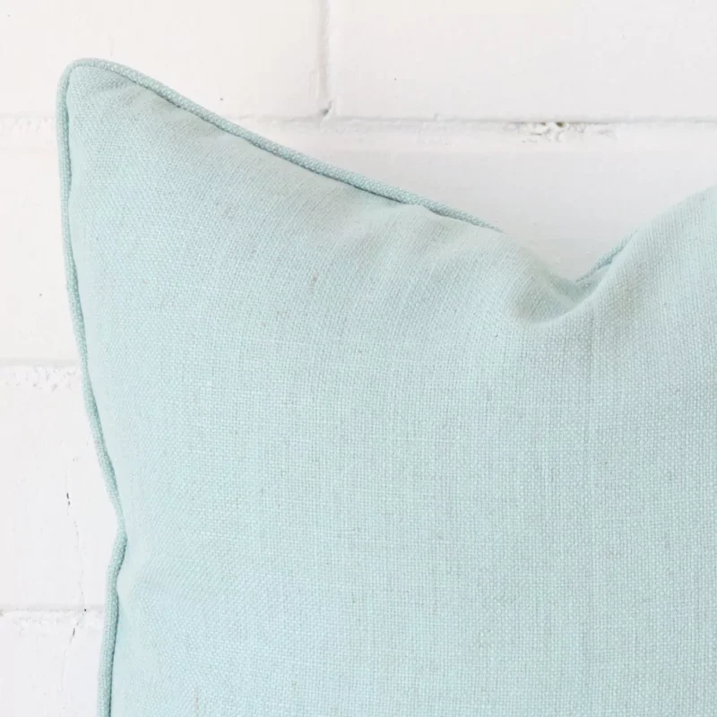 A magnified shot of a linen cushion cover in a square size and a mint colour.