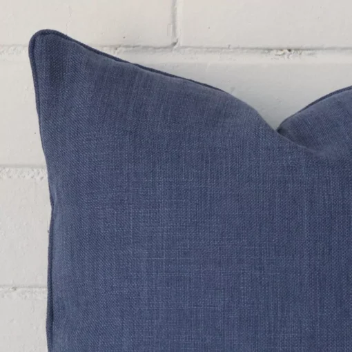 A royal blue linen cushion cover’s corner is shown in more detail. It has a square design.