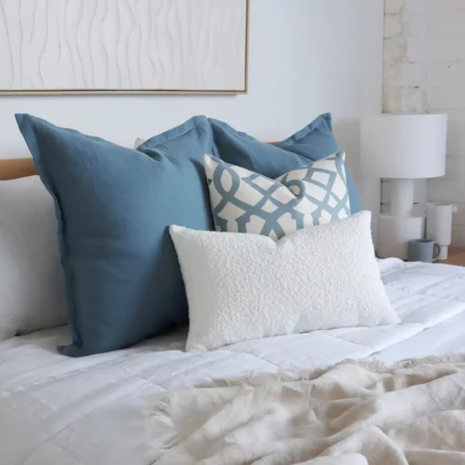 A side-view shot of a set of 4 Mia bed cushions in a bright bedroom.