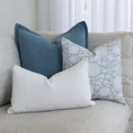 A corner of a grey sofa is styled with the 3 cushions from the set.