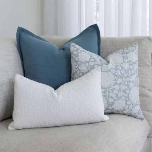 A corner of a grey sofa is styled with the 3 cushions from the set.