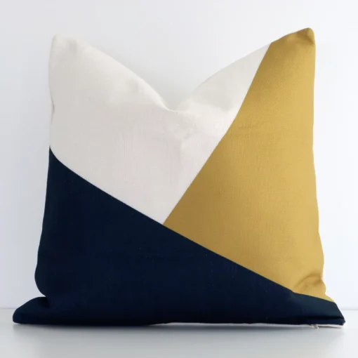 Colourful linen cushion cover features prominently against a white wall. It is a square design and has a geometric decorative finish.
