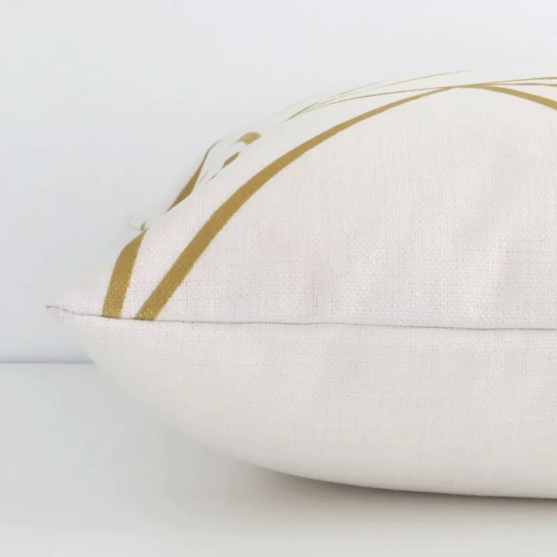 A square cushion with a gold mustard print cover laying flat. This viewpoint highlights the geometric style and linen fabric.