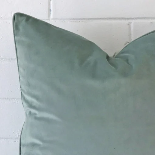 Close up of a velvet large cushion in mint blue.