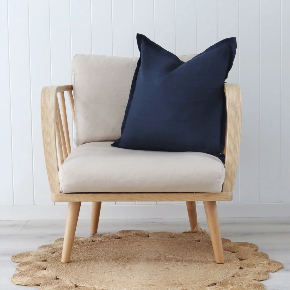 A modern chair in a light room with a navy cushion.