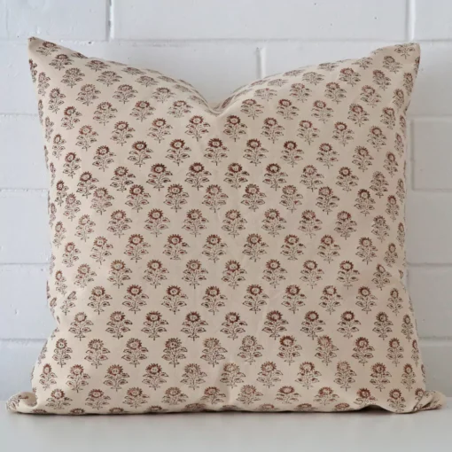 A lovely large cushion cover arranged in front of a white wall. The floral style complements the designer material.