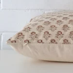 A large designer cushion cover shown laying on its side. The floral design is shown side on.