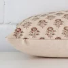 Lateral angle image of a designer rectangle cushion. The floral design are highlighted along its seams.