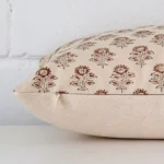 Lateral angle image of a designer rectangle cushion. The floral design are highlighted along its seams.