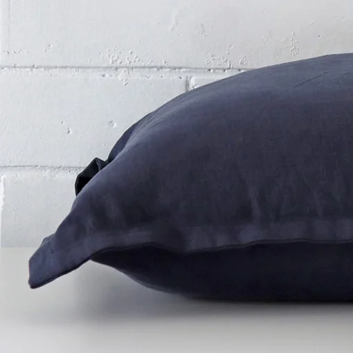 Side shot showing the seam of this large navy cushion that is made from a linen material.