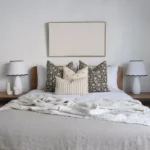 The Nellie designer set of 4 cushions on a wooden bed.