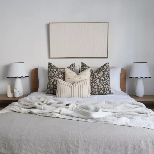 The Nellie designer set of 4 cushions on a wooden bed.
