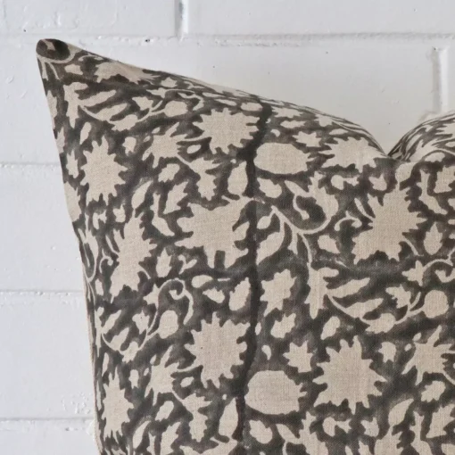 Close up of a designer large cushion. The quality of its floral design is shown in fine detail.