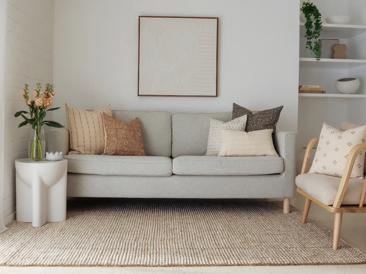 A neutral coloured arrangement of cushions on a grey sofa that have been purposefully colour matched.