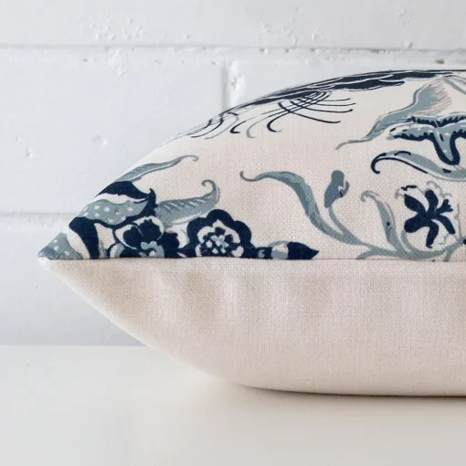 Side shot showing the seam of this square cushion that features a floral motif on its linen material.