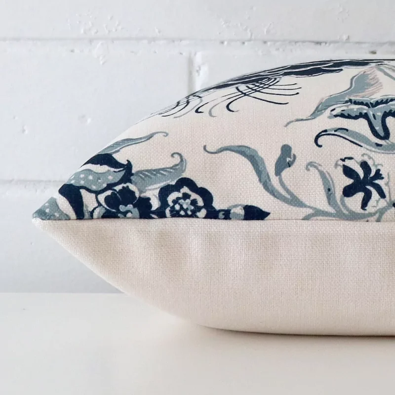 Side shot showing the seam of this square cushion that features a floral motif on its linen material.