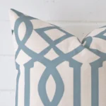 Enlarged shot of the corner of this square patterned cushion cover against a brick wall. The image shows the quality and craftsmanship of the linen material.