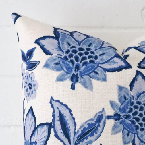 A linen square cushion’s corner has been enlarged in this shot. It has a beautiful floral design.