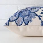 Enlarged image of the side of this linen cushion. The angle highlights how the square design and floral decorative finish are joined along the seam.