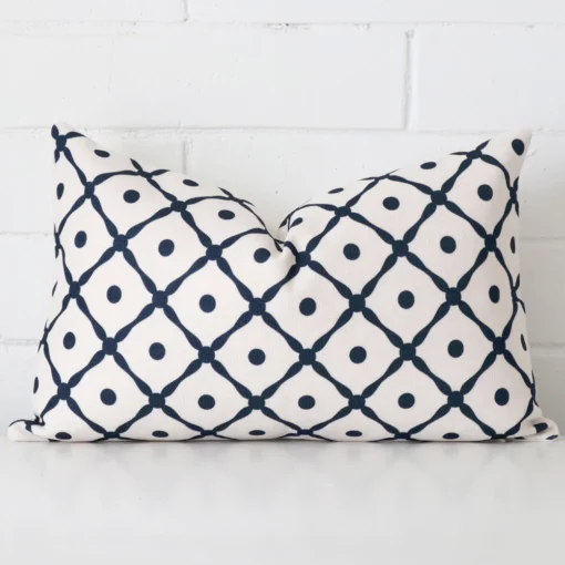 Cushion positioned in front of a brick wall. It has rectangle dimensions and is made from a linen material.