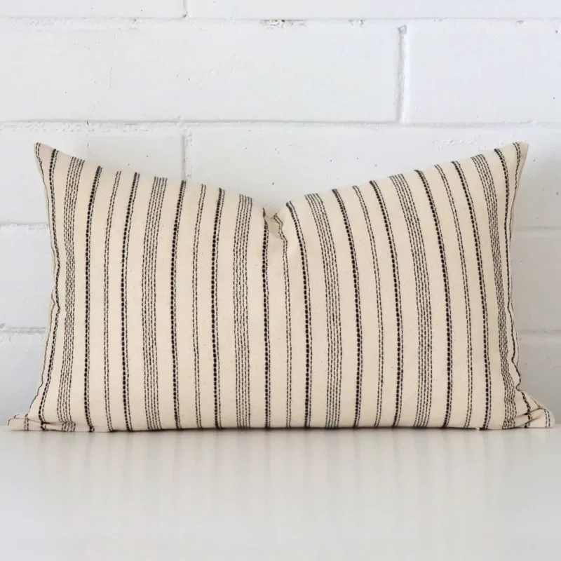 nico-striped-designer-cushion-cover-rectangle-art104-30b A designer rectangle cushion cover that has a unique striped design is shown vertically against a brick wall.