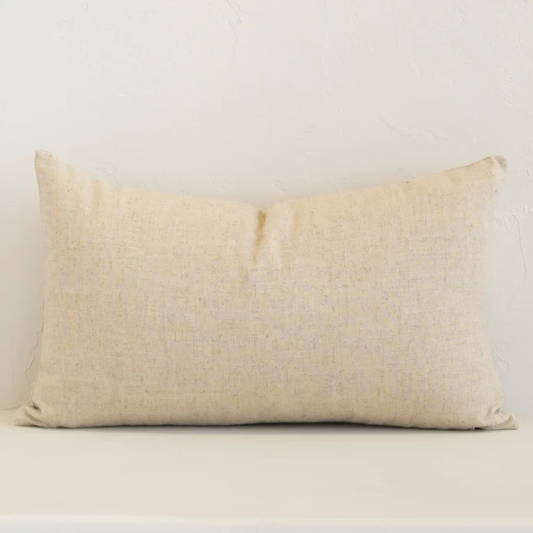 Linen rectangle cushion with a solid-coloured design in an upright position against a wall. It is natural in colour.