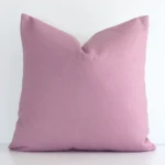 A hero shot of a linen square cushion cover. It is made from a deluxe linen fabric and features a blush colour.