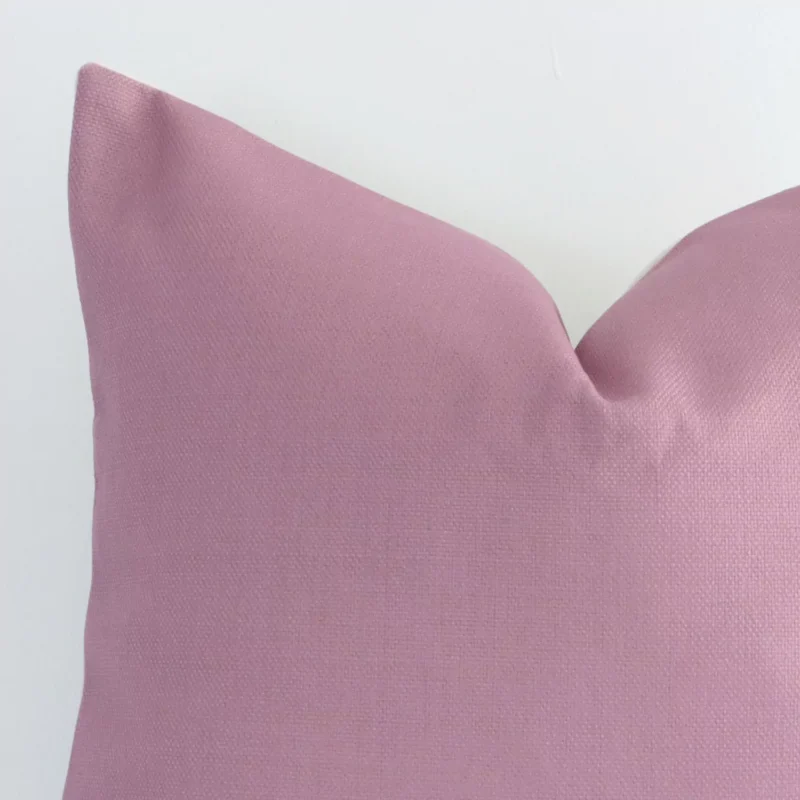 Macro image of a linen square cushion cover. The shot shows the blush hue and solid colour style more thoroughly.