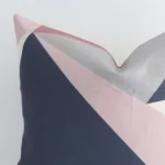 A colourful linen cushion cover’s corner is shown in more detail. It is possible to see the square design and geometric decorative finish in much more detail.