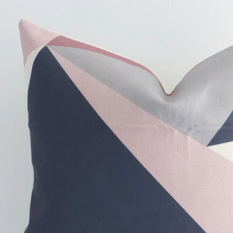 A colourful linen cushion cover’s corner is shown in more detail. It is possible to see the square design and geometric decorative finish in much more detail.
