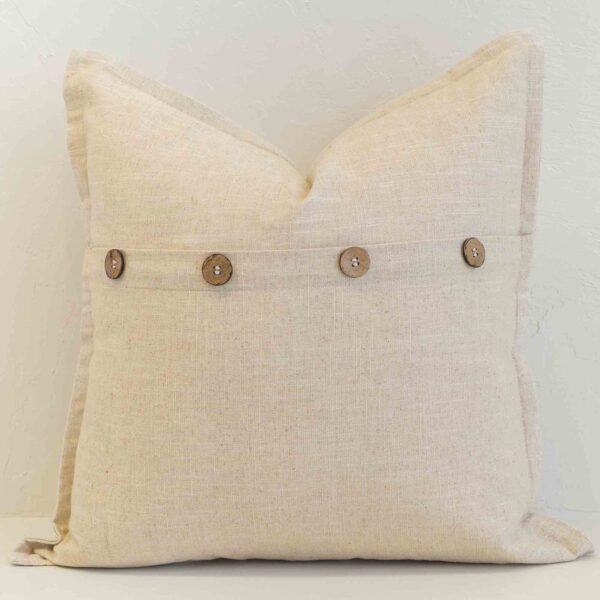 Oatmeal linen cushion with button closure detail and natural woven texture.