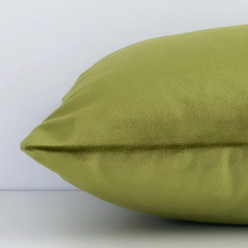 Lateral viewpoint of this velvet rectangular cushion. The solid colour design in olive is shown from the side showing the front and rear panels.