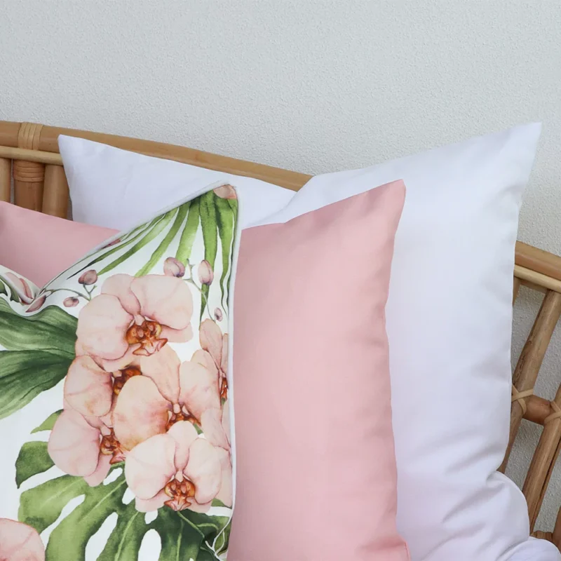 A close-up image of 3 pink outdoor couch cushions provides a thorough view of the colour hue and style.