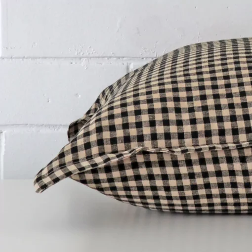 Enlarged image of the side of this large designer cushion. The angle highlights the gingham decorative finish.