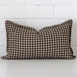 A rectangle gingham cushion in a delightful tone rests against a white wall. The designer material appears to be of exceptional quality.