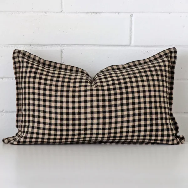 A rectangle gingham cushion in a delightful tone rests against a white wall. The designer material appears to be of exceptional quality.
