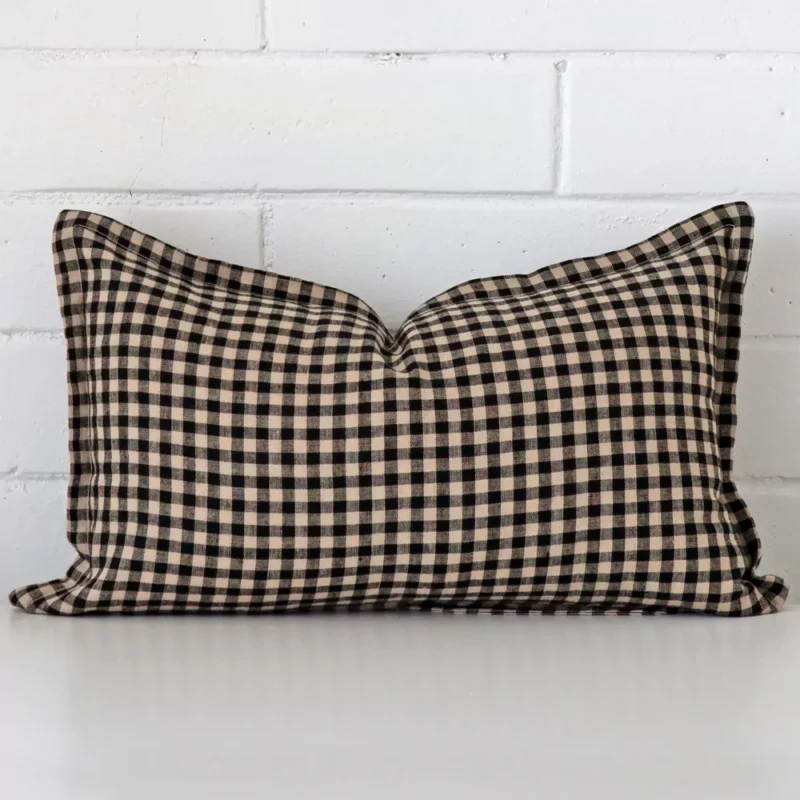 A rectangle gingham cushion in a delightful tone rests against a white wall. The designer material appears to be of exceptional quality.