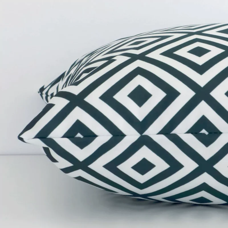 Side image of a outdoor square cushion cover. The geometric design and green colour are visible from the side showing the attachment of the panels.