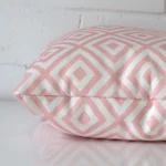 Side angle of pink geometric cushion cover that has outdoor fabric and a square size.