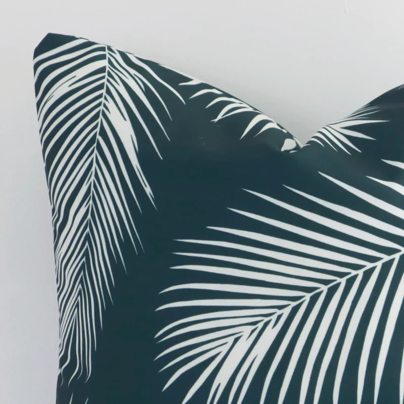 Close up of an outdoor square cushion in green. The quality of its palm design is shown in fine detail.