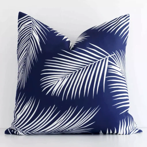 A bold palm motif outdoor cushion in a sleek square size with a navy tone of colour.