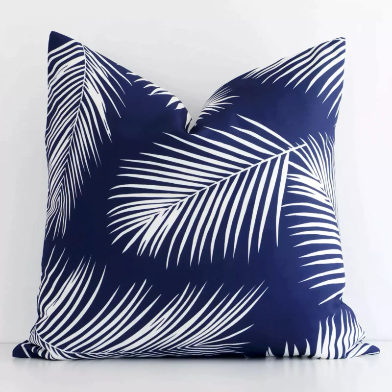 A bold palm motif outdoor cushion in a sleek square size with a navy tone of colour.