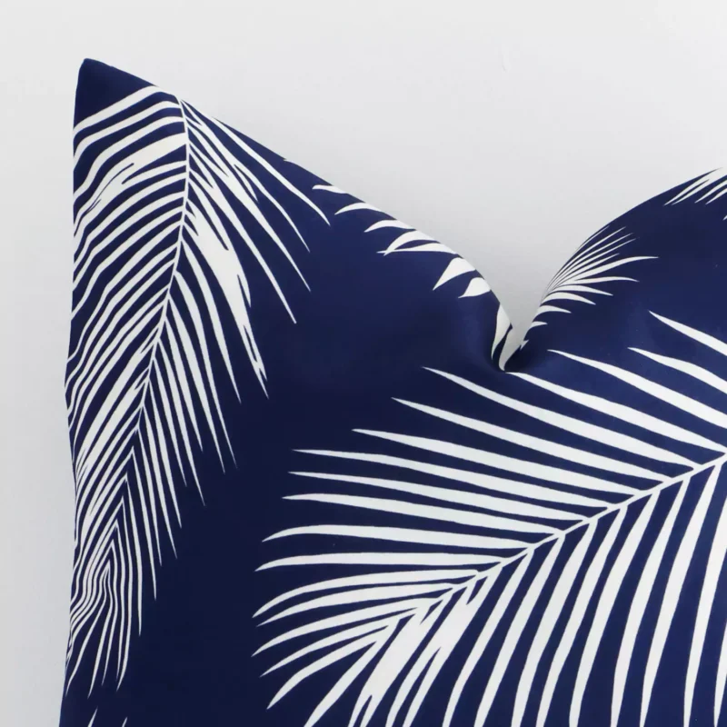Close up image of top corner of this palm printed navy cushion. This shows the outdoor fabric and square shape up close.