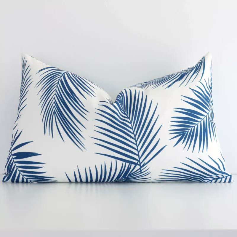 otama-palm-waterproof-rectangular-blue-outdoor-cushion-cover-rectangle-sc952-30 An outdoor rectangular cushion cover that has a unique palm design is shown vertically against a white wall. It has a wonderful blue print colour.